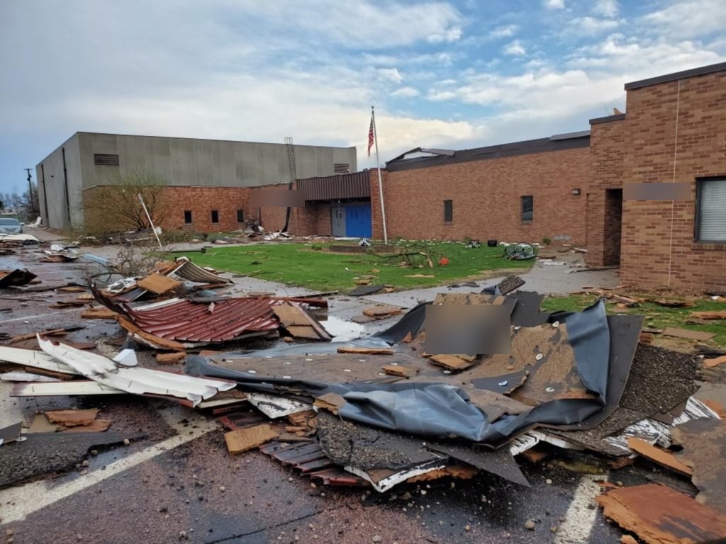 Wind-damaged roof and building debris