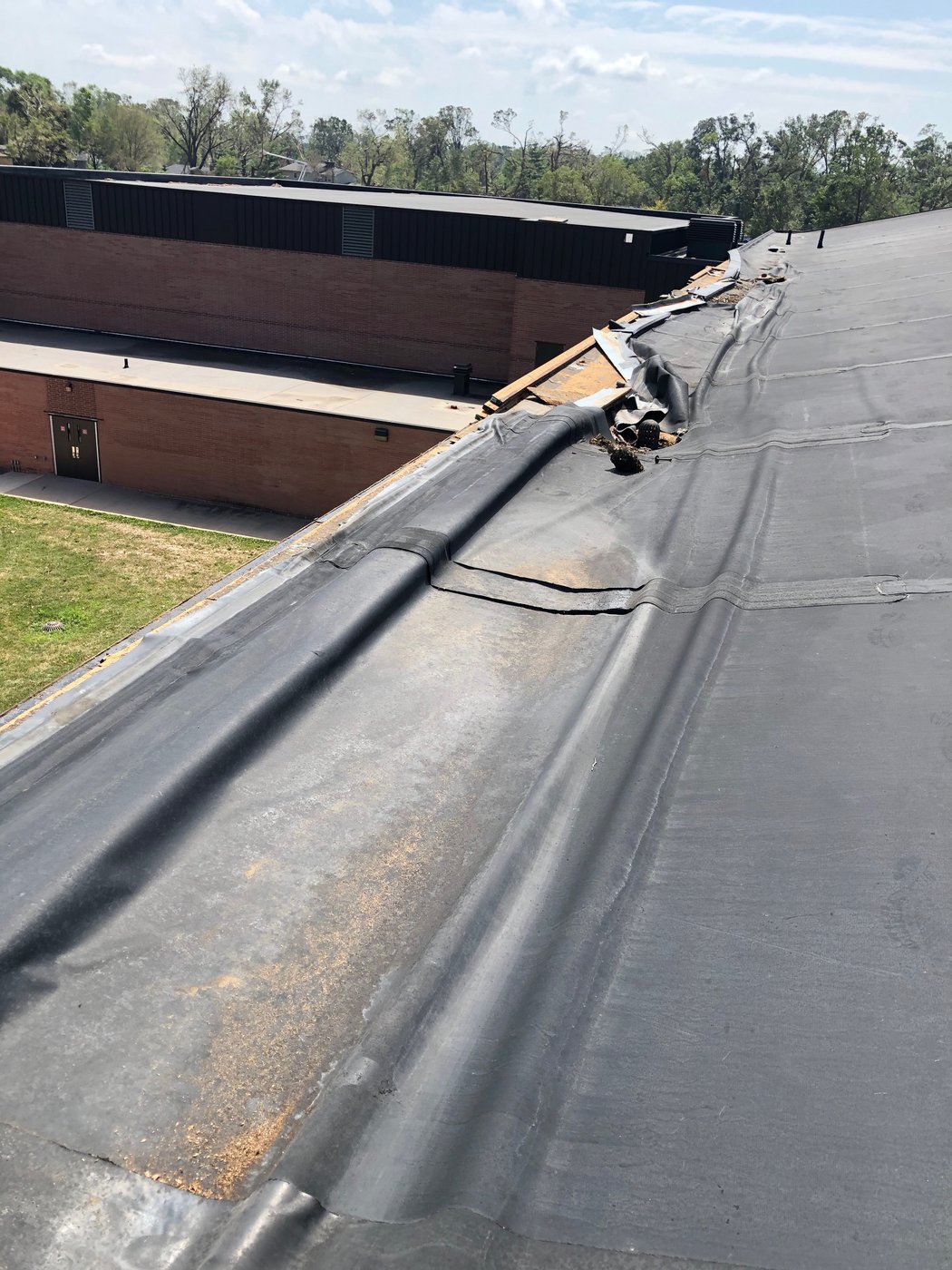 Wind-damaged commercial roof membrane